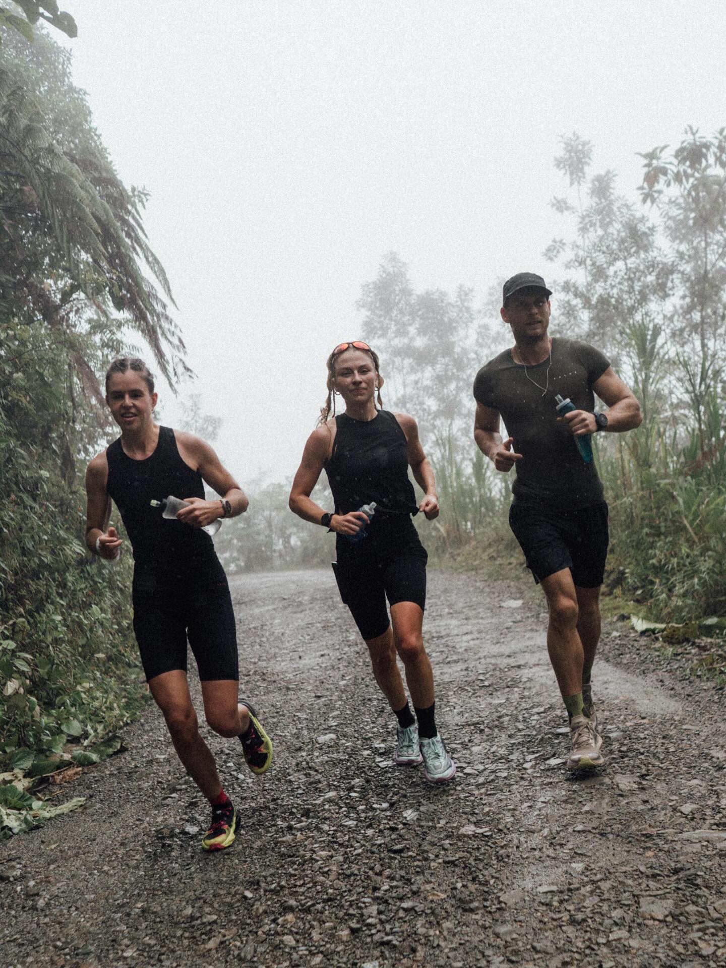 Paweł leading two athletes through a jungle trail